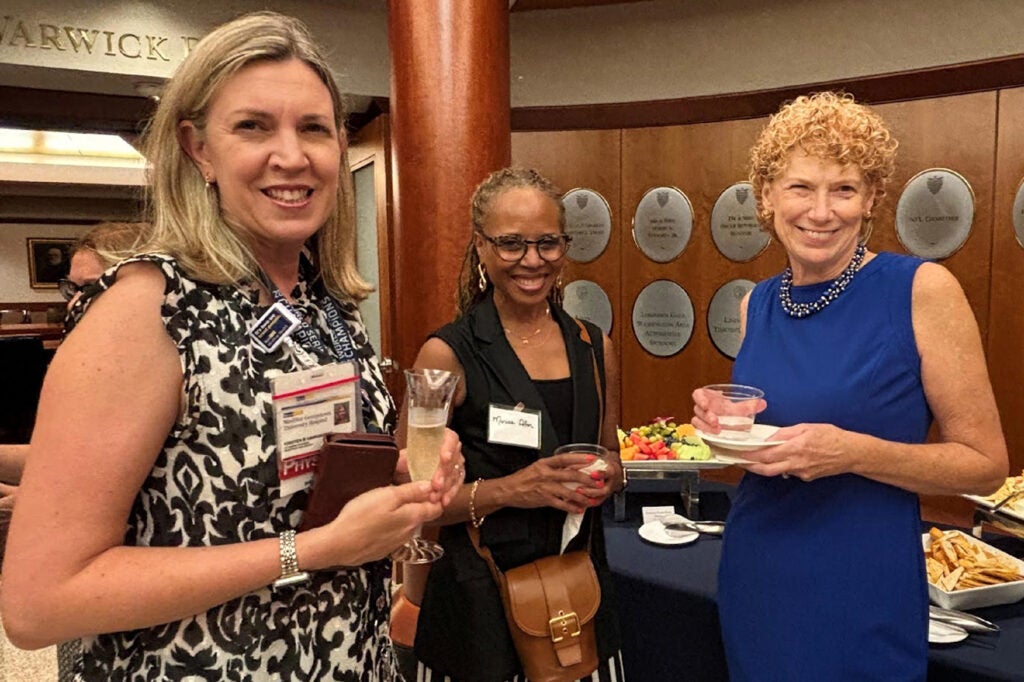 Three GWIM board members stand together at a reception